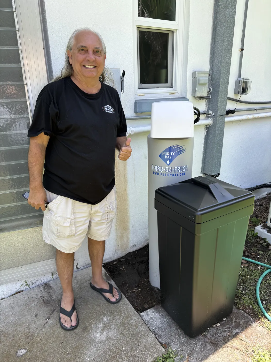 Clearwater homeowner beside his Purity Bay 3X Essential whole home water system