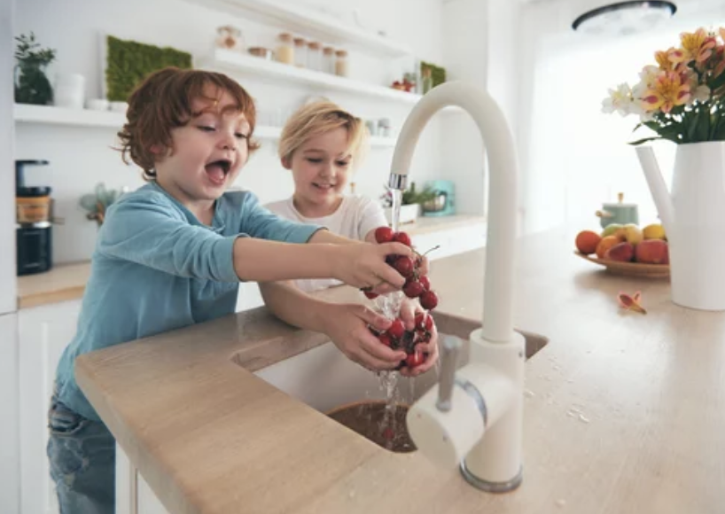 Family enjoying time together at their kitchen sink